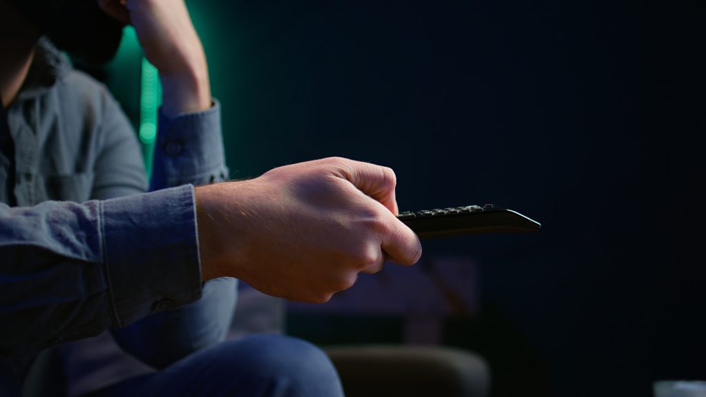 close up man couch using remote control
